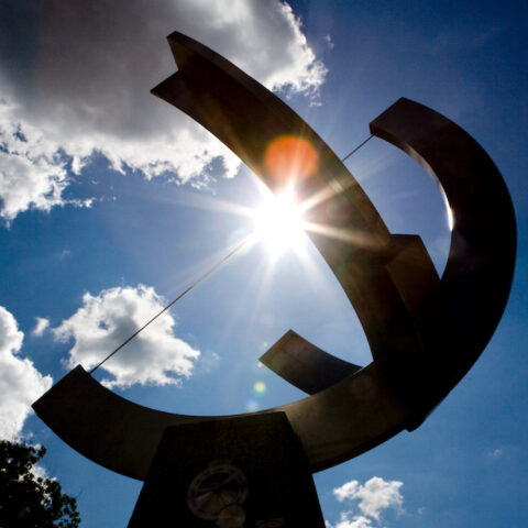 Cornell sundial in front of a blue sky with clouds
